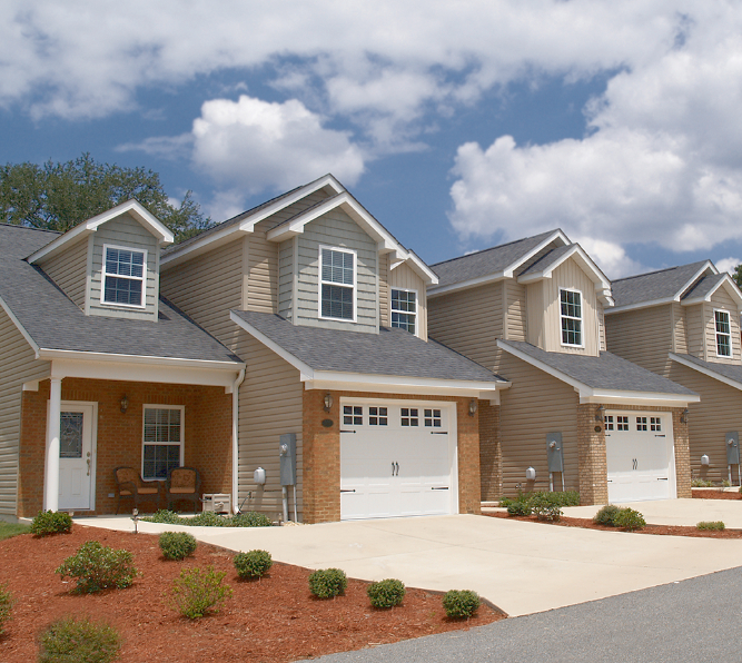 Row of townhomes with attached garages and landscaped front yards