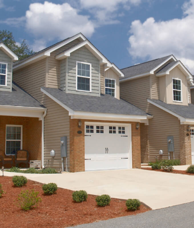 Row of townhomes with attached garages and landscaped front yards