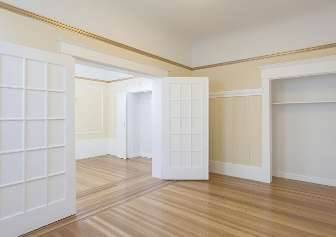 Bright empty rental interior with hardwood floors and white French doors